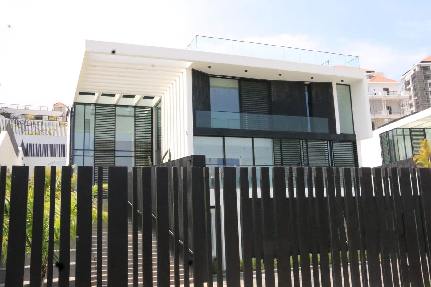 Modern villa behind a black slatted fence